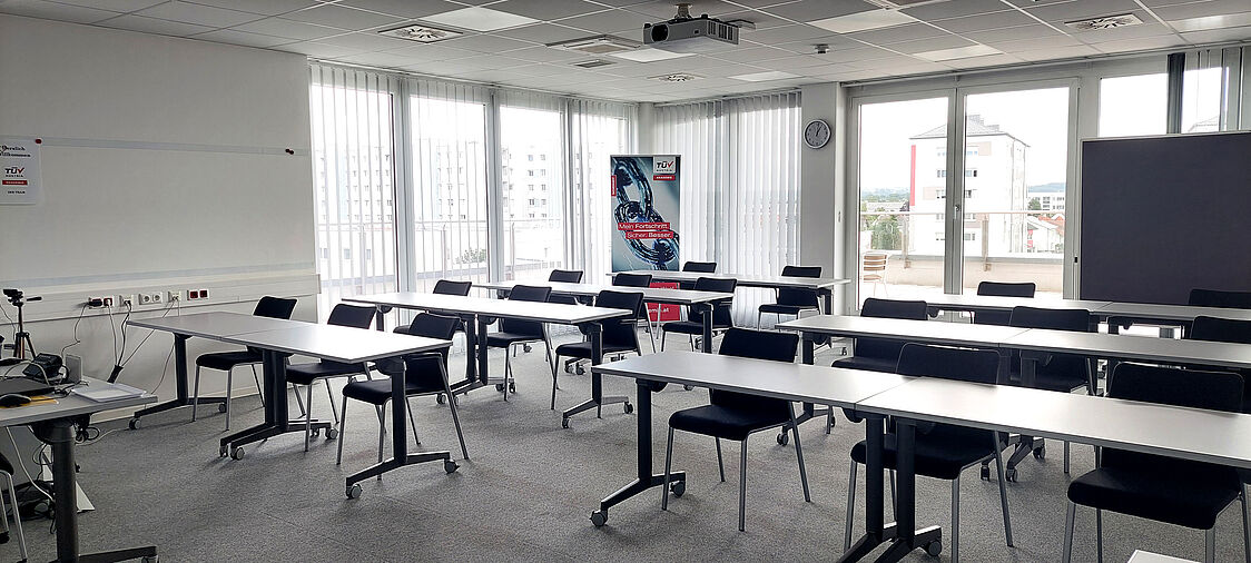 Beispiel Seminarraum in Leonding<br /> Ein Seminarraum. Tische Stühle, großflächige Fenster.