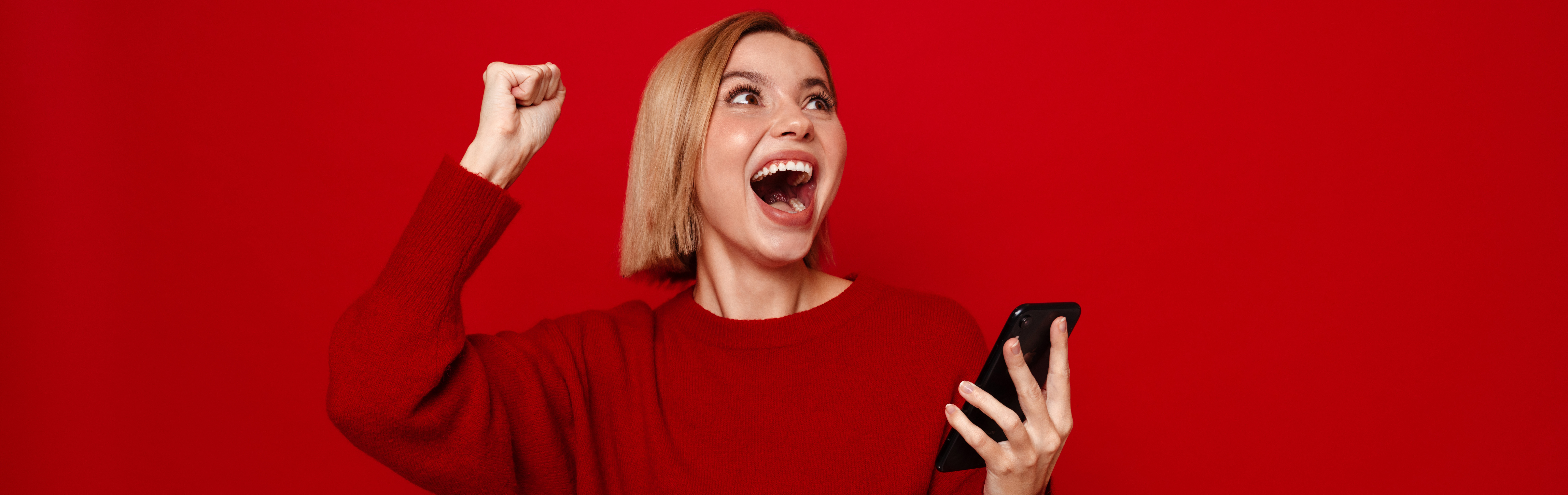 Dame freut sich und hält Smartphone in der Hand. Sicher. Besser.: das Gewinnspiel zum neuen Kursprogramm!